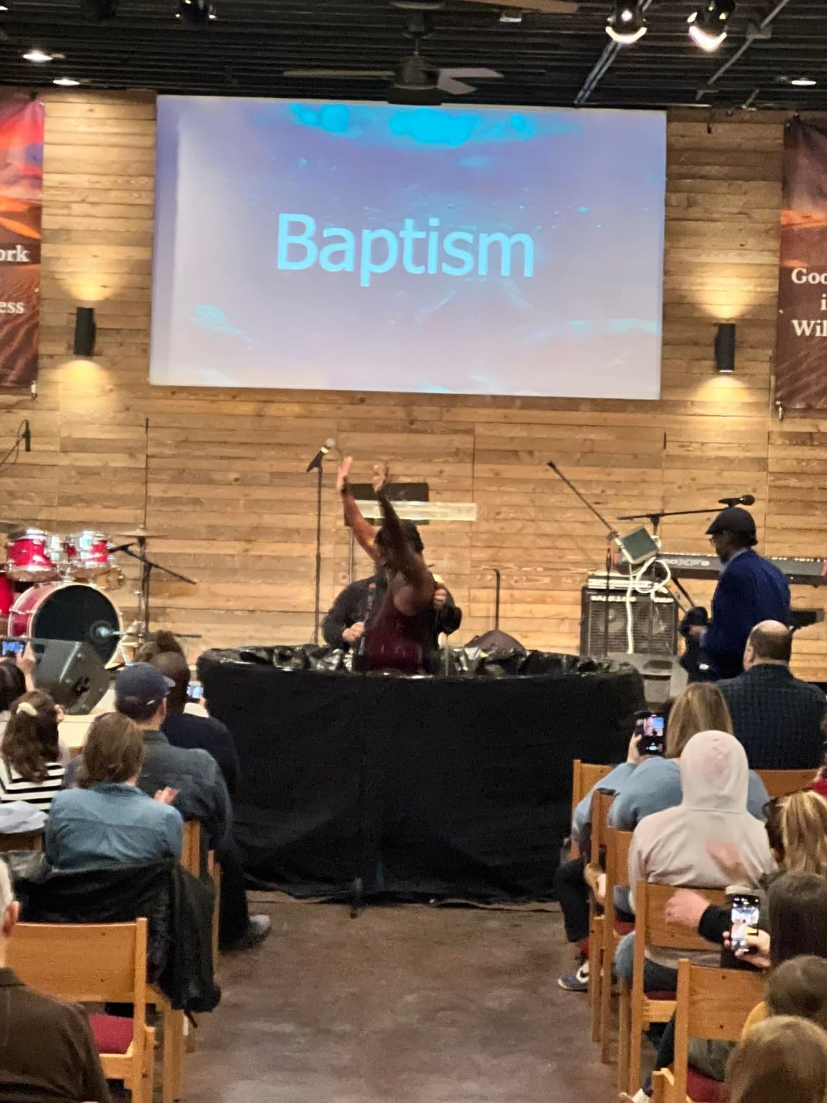 A baptism during a Sunday service, hands raised