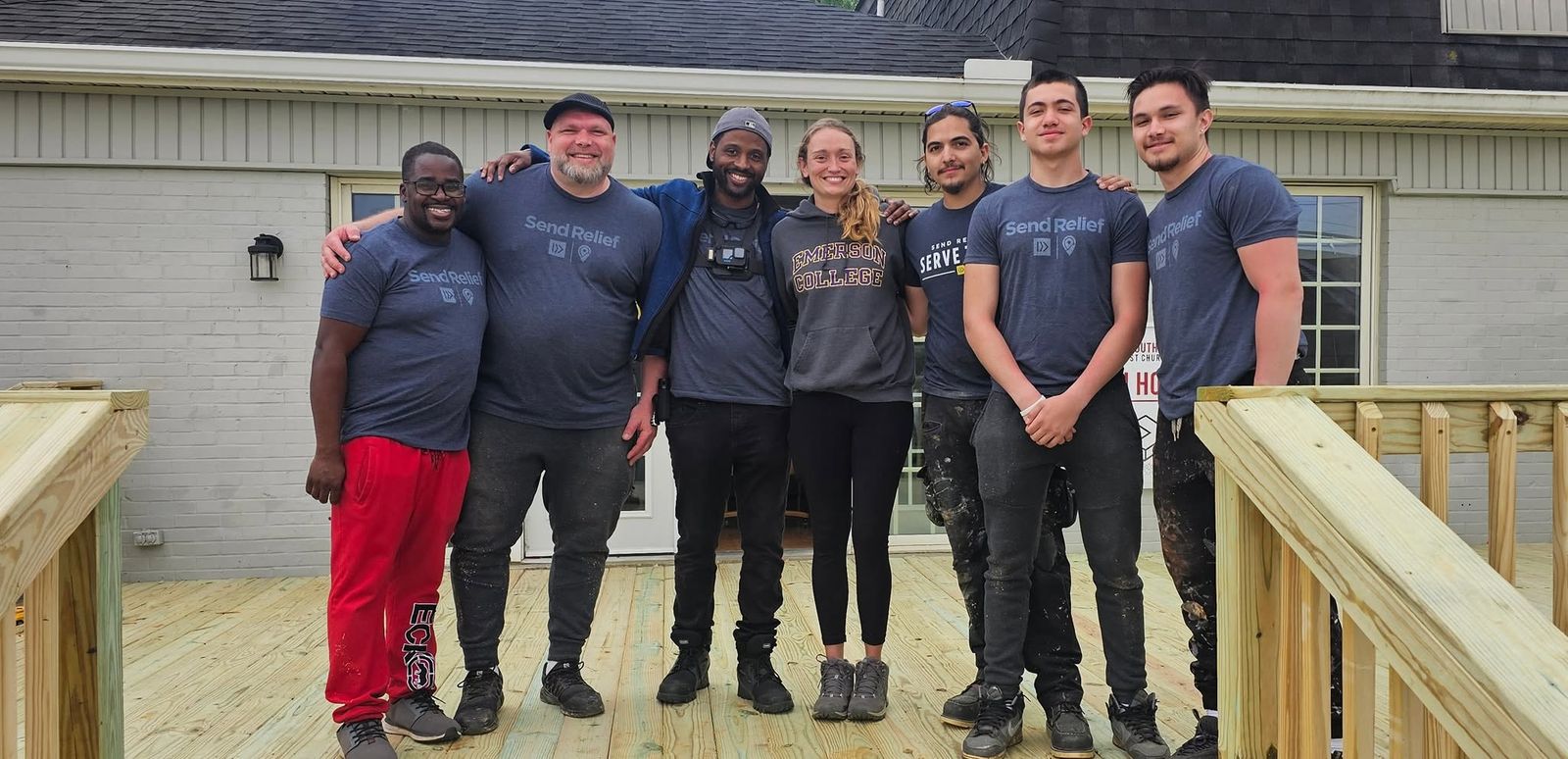 A volunteer work team in matching shirts on a deck they built
